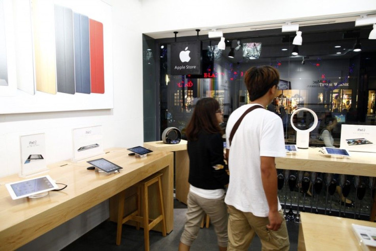 Customers walk past products in a fake Apple Store in Kunming, Yunnan province July 22, 2011.