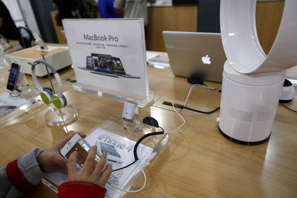 A boy plays with an iPhone 4 display set inside a fake Apple Store in Kunming, Yunnan province July 22, 2011.