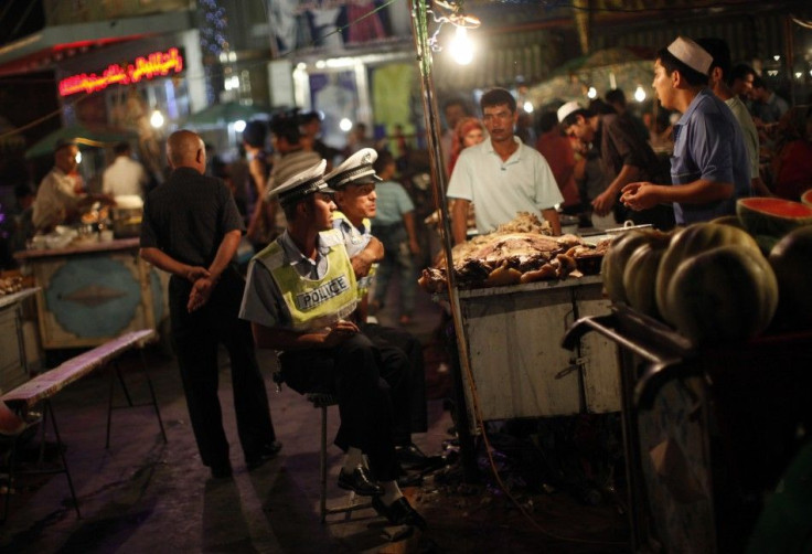 Police officers eat at an Uighur ethnic market area in Kashgar