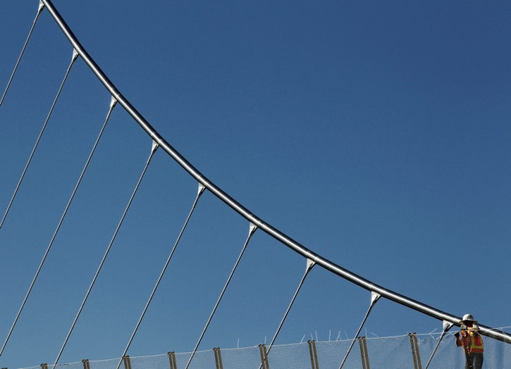 A worker constructs a fence as he helps with the building of a pedestrian bridge in downtown San Diego