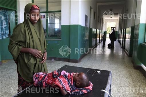 Somali woman attends to her malnourished child along corridor of paediatric ward at Banadir hospital in southern Mogadishu
