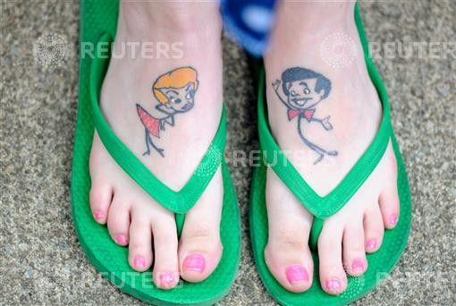 Wilson shows tattoos of Lucy and Ricky Ricardo on her feet, as she takes part in attempt to set new Guinness world record for most Lucy lookalikes assembled in one place, in Jamestown.