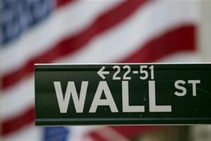 A Wall Street sign hangs on a signpost in front of the New York Stock Exchange