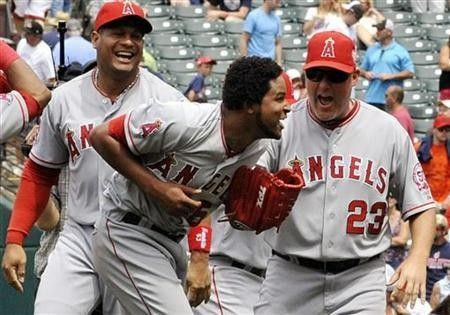 Los Angeles Angels' pitcher Ervin Santana (C) celebrates with pitching coach Mike Butcher (23) and Bobby Abreu (L) after throwing a no hitter during the MLB American League baseball game against the Cleveland Indians in Cleveland, Ohio