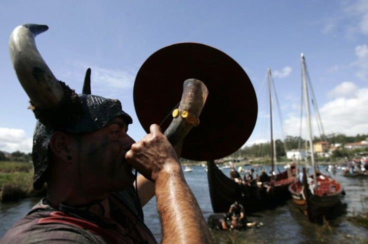 A participant dressed up as a Viking blows a horn as he takes part in the annual Viking festival of Catoira in north-western Spain