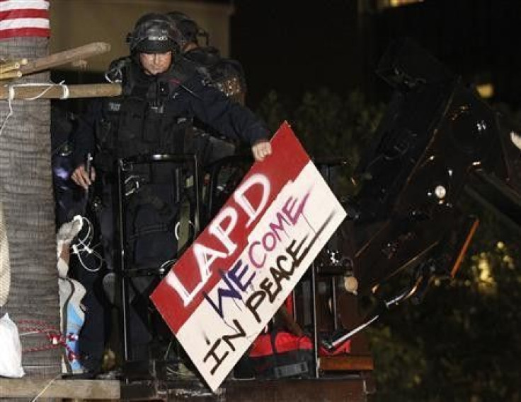 A police officer removes a sign from a tree house from a cherry picker crane as the Occupy LA encampment is dismantled outside City Hall in Los Angeles