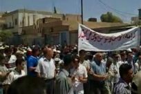 Protesters march while holding banners in Qamishli, northeast Syria