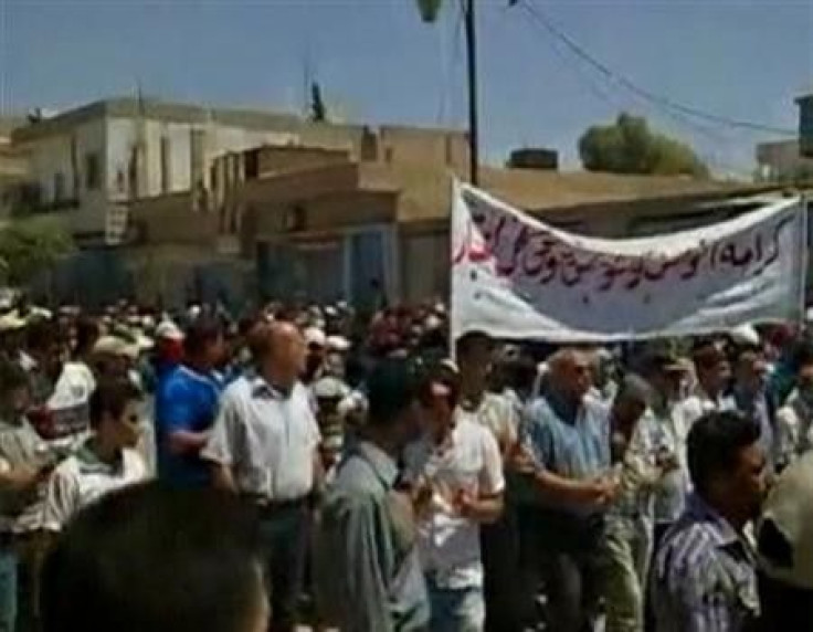 Protesters march while holding banners in Qamishli, northeast Syria