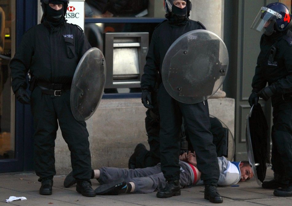 Police officers detain a man