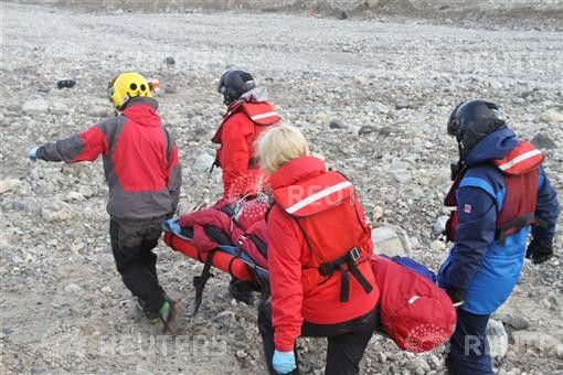 Rescuers carry one of the four youths injured in a polar bear attack on Spitsbergen