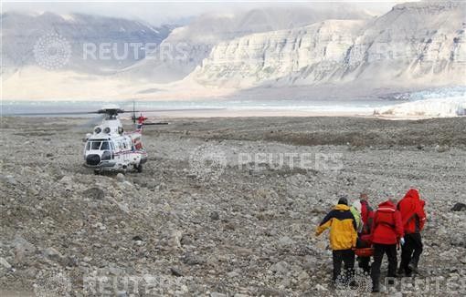 Rescuers carry one of the four youths injured in a polar bear attack on Spitsbergen island