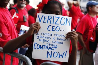 A girl holds a sign as workers rally outside the Verizon headquarters in New York