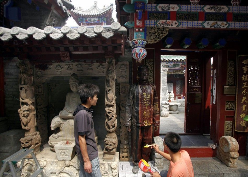 Artist Liu stands very still alongside the temple as body