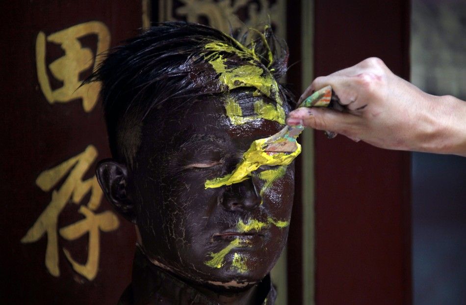 Artist Liu is painted by assistants as