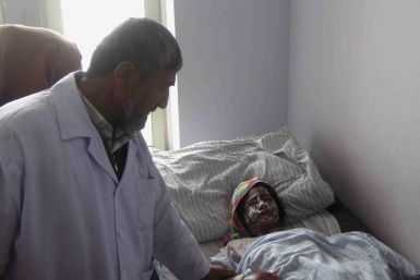 An Afghan woman receives treatment at a hospital after her family was attacked with acid at her home by unknown gunmen in Kunduz