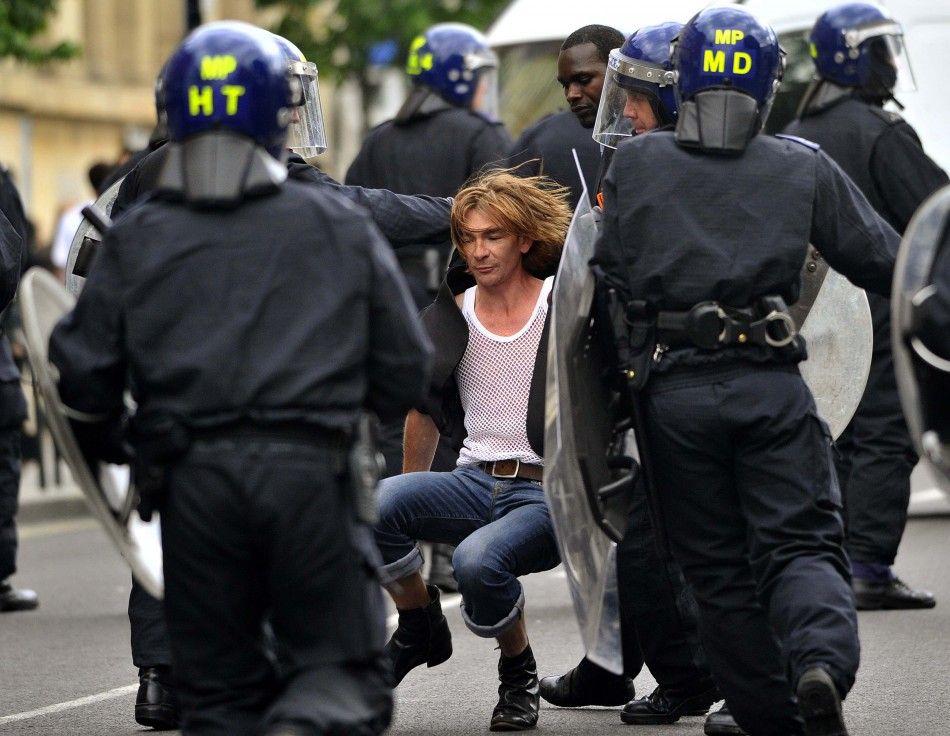 Police officers in riot gear drag a man along a street in Hackney, east London August 8, 2011
