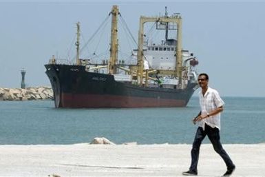 A man walks past Libyan-chartered ship Amalthea carrying aid for Palestinians in Gaza sailing in El Arish port,