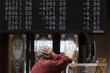 A trader stands in front of screens at the bourse in Madrid