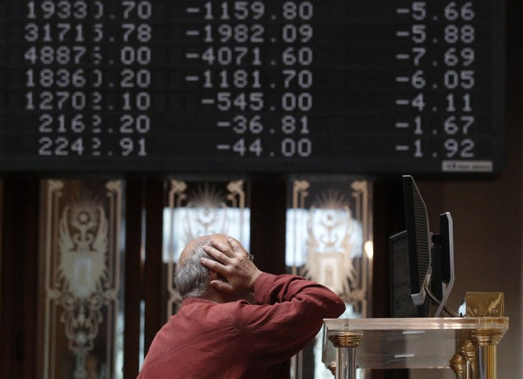 A trader stands in front of screens at the bourse in Madrid