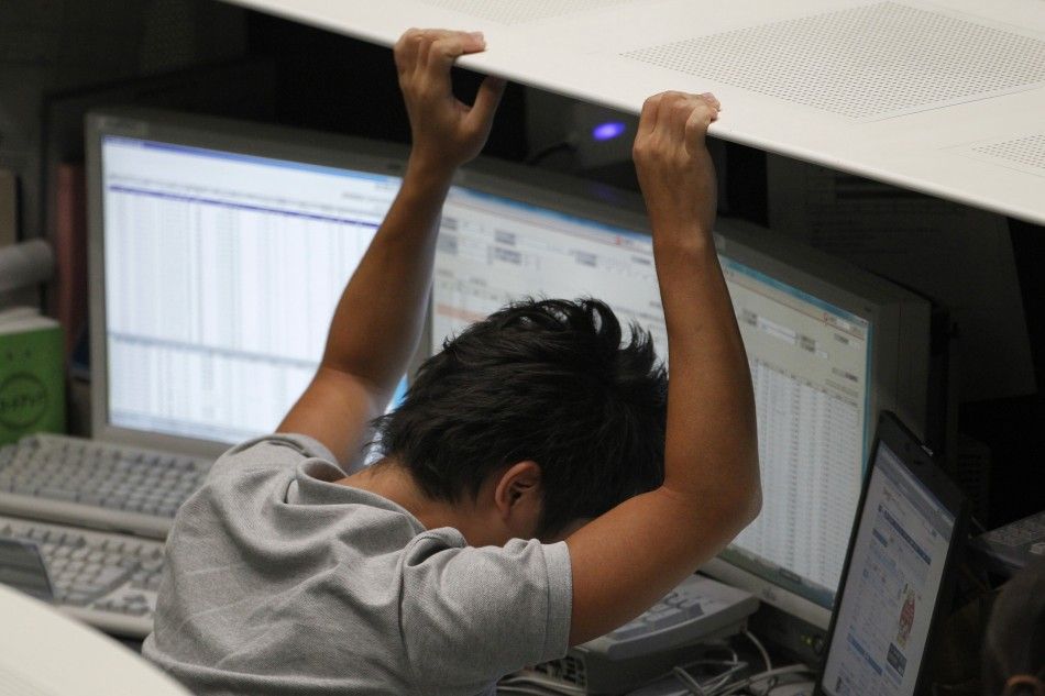 An employee of the TSE reacts as he works at the bourse in Tokyo