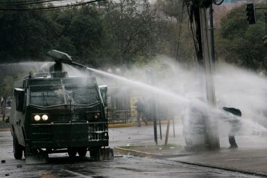 Riot policemen use a water cannon on student protesters in Santiago, Chile.