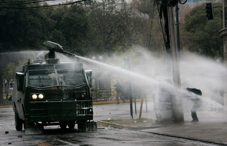Riot policemen use a water cannon on student protesters in Santiago, Chile.