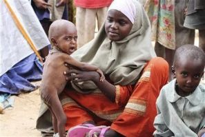 An internally displaced woman sits with her malnourished children