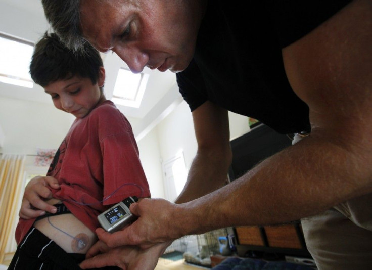 Ed Damiano (right) delivers insulin to his son David, at the family&#039;s home in Acton, Mass. Damiano is working on a bionic pancreas that will automatically control blood glucose in people with type 1 diabetes.