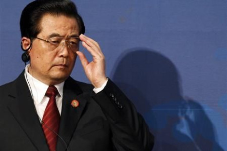 China's President Hu Jintao adjusts his glasses at the APEC CEO Summit in Yokohama