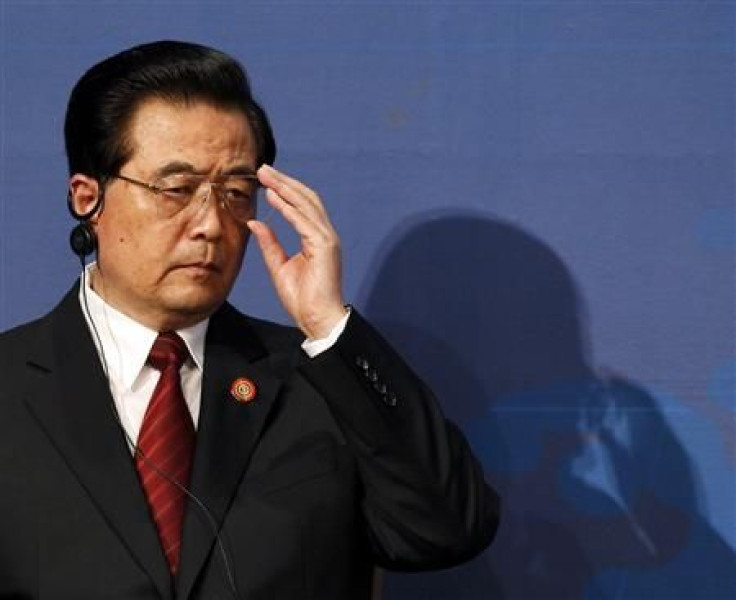 China's President Hu Jintao adjusts his glasses at the APEC CEO Summit in Yokohama