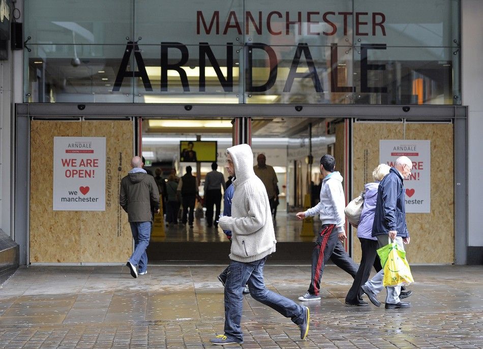 People walk past a boarded up entrance to the Arndale centre in Manchester, northern England