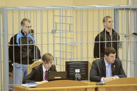 File photo of Konovalov and Kovalyov standing in a guarded cage during a hearing in Minsk