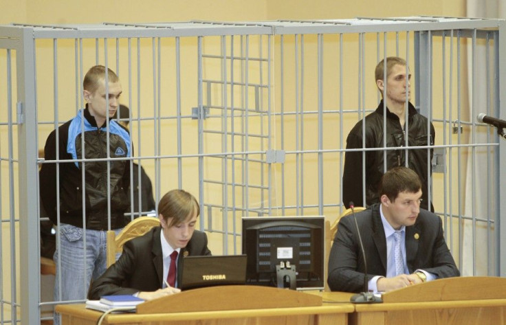 File photo of Konovalov and Kovalyov standing in a guarded cage during a hearing in Minsk