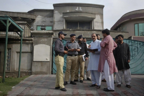 Police and security officials gather outside the residence of an American citizen after he was kidnapped in Lahore