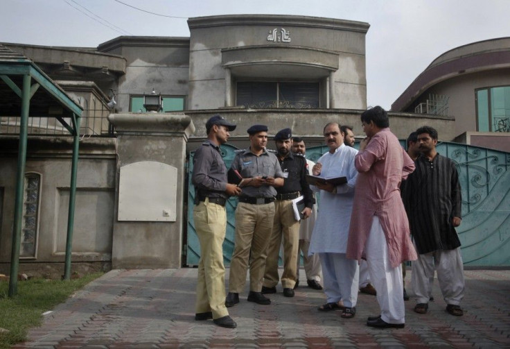 Police and security officials gather outside the residence of an American citizen after he was kidnapped in Lahore