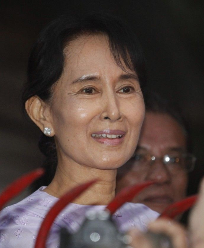 Aung San Suu Kyi speaks with supporters outside her home, where she was placed under house arrest for seven years, in Yangon