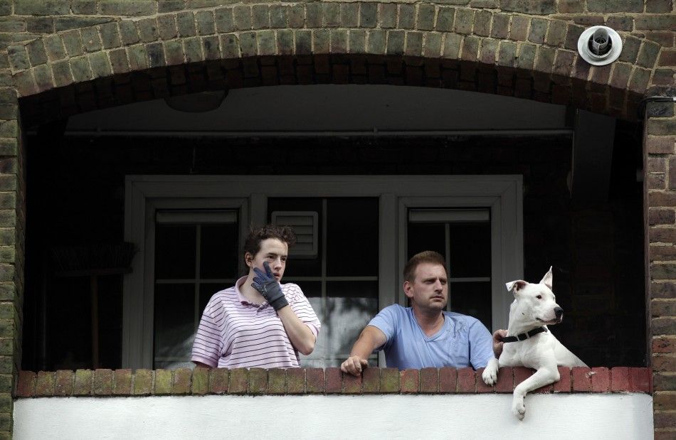 Residents of a housing estate watch as demonstrators march in north east London