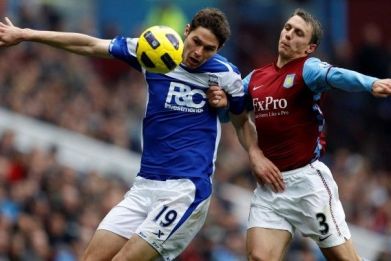 Aston Villa's Warnock challenges Birmingham City's Zigic during their English Premier League soccer match in Birmingham.