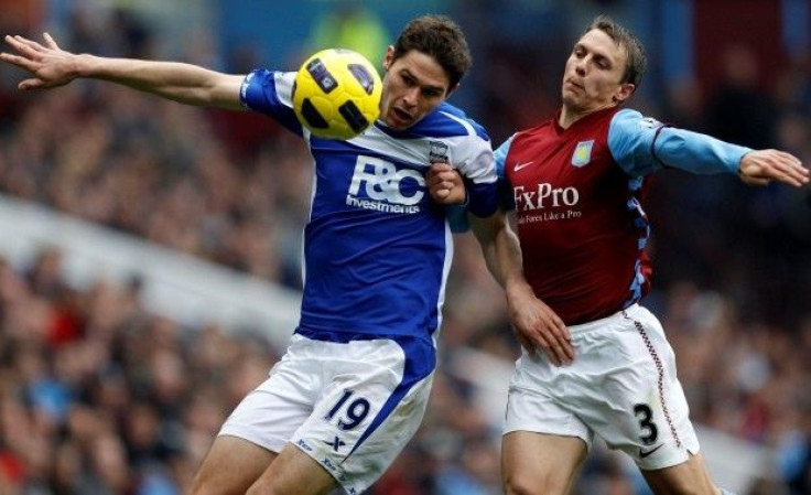 Aston Villa's Warnock challenges Birmingham City's Zigic during their English Premier League soccer match in Birmingham.