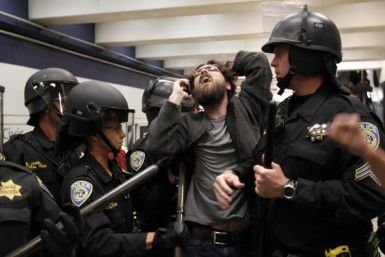 A protester is surrounded by police during a demonstration at the BART Civic Center Station in San Francisco