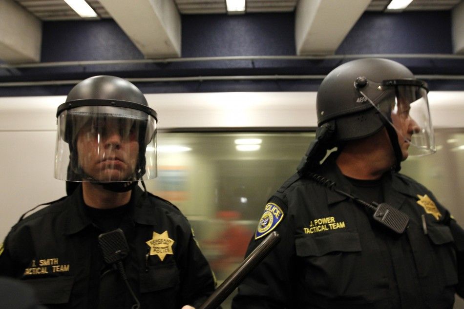 Police stand guard at a train platform during a demonstration at the BART Civic Center Station in San Francisco