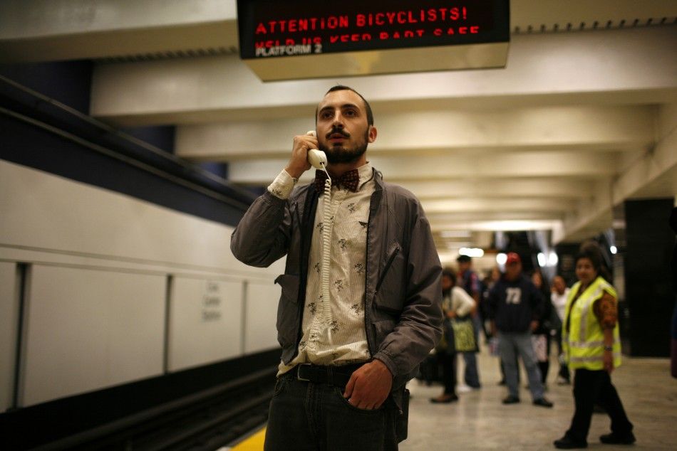 A protester talks on the detached handset of a telephone during a demonstration at the BART Civic Center Station in San Francisco