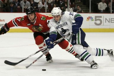 Vancouver Canucks&#039; Rypien battles Chicago Blackhawks&#039; Seabrook for the puck in the second period of their NHL game in Chicago