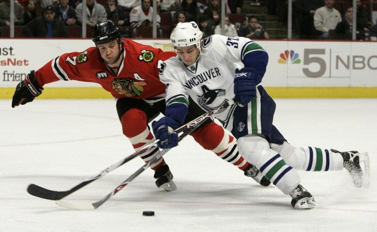 Vancouver Canucks&#039; Rypien battles Chicago Blackhawks&#039; Seabrook for the puck in the second period of their NHL game in Chicago