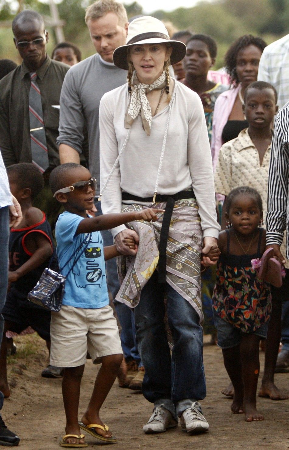 Madonna walks with her adopted children, David L and Mercy at the Mphandula Child Care Centre, about 47 km 29 miles west of Lilongwe, October 29, 2009. 