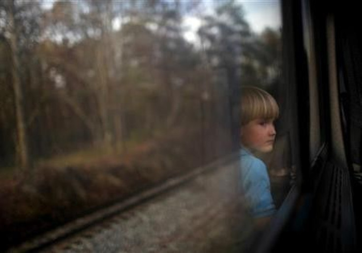 A boy watches through a window of an Amtrak train from Birmingham to Anniston