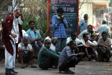 Daily wage workers wait for employment on a street side at an industrial area in Mumbai 