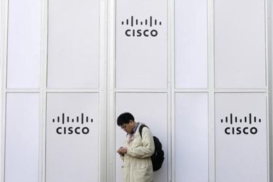 A man looks at his mobile next to a Cisco banner at the Mobile World Congress in Barcelona