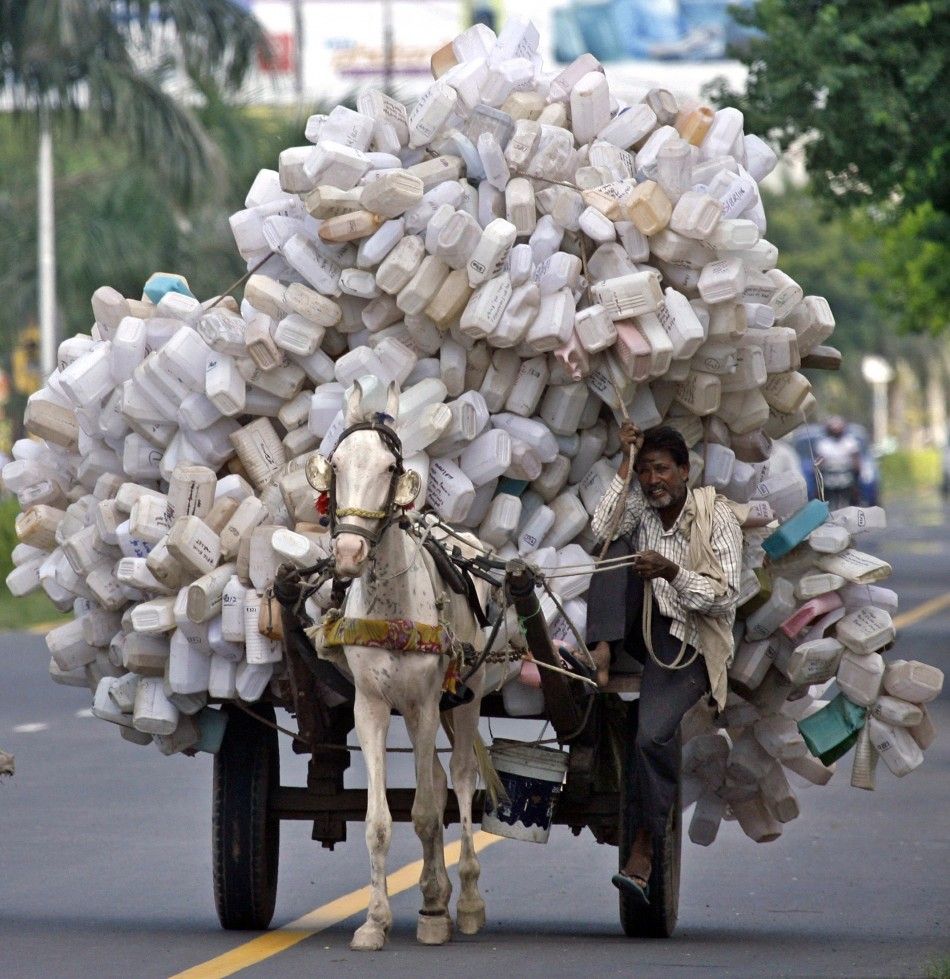 A man transports used empty plastic cans on a horse cart to a junkyard at Panchkula
