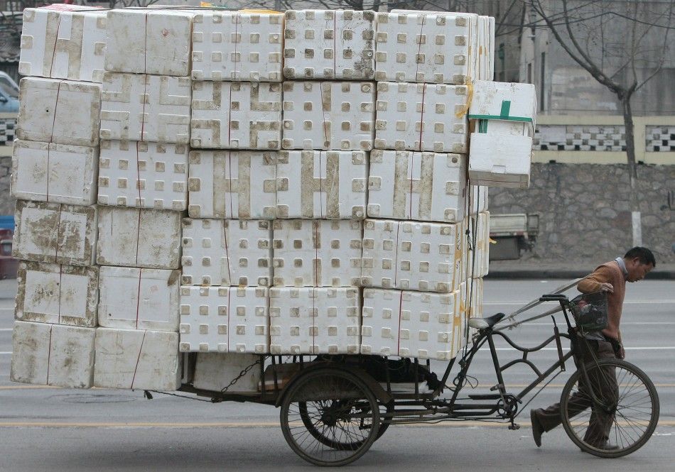 A migrant worker pulls a cart loaded with discarded plastic foam for recycling in Nanjing